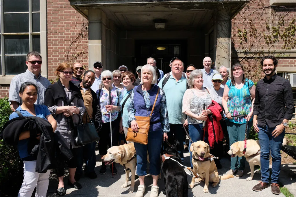 A group of people from the CNIB standing outside the planetarium building